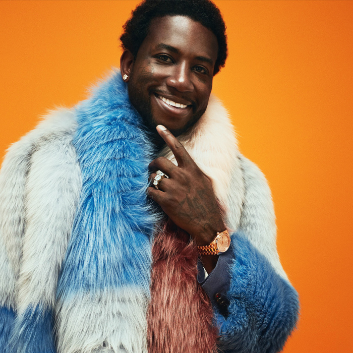Black man named Guccimane with blue and white top smiling