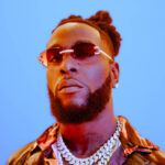 Black man named Burnaboy with a blue background