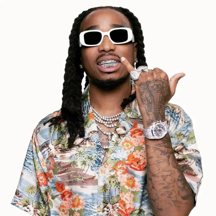 black man named quavo smiles into the camera on a white background