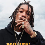 black man named wizkhalifa smoking with a cigarette in his hand